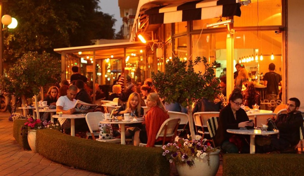 people sitting in tel aviv cafe in the evening